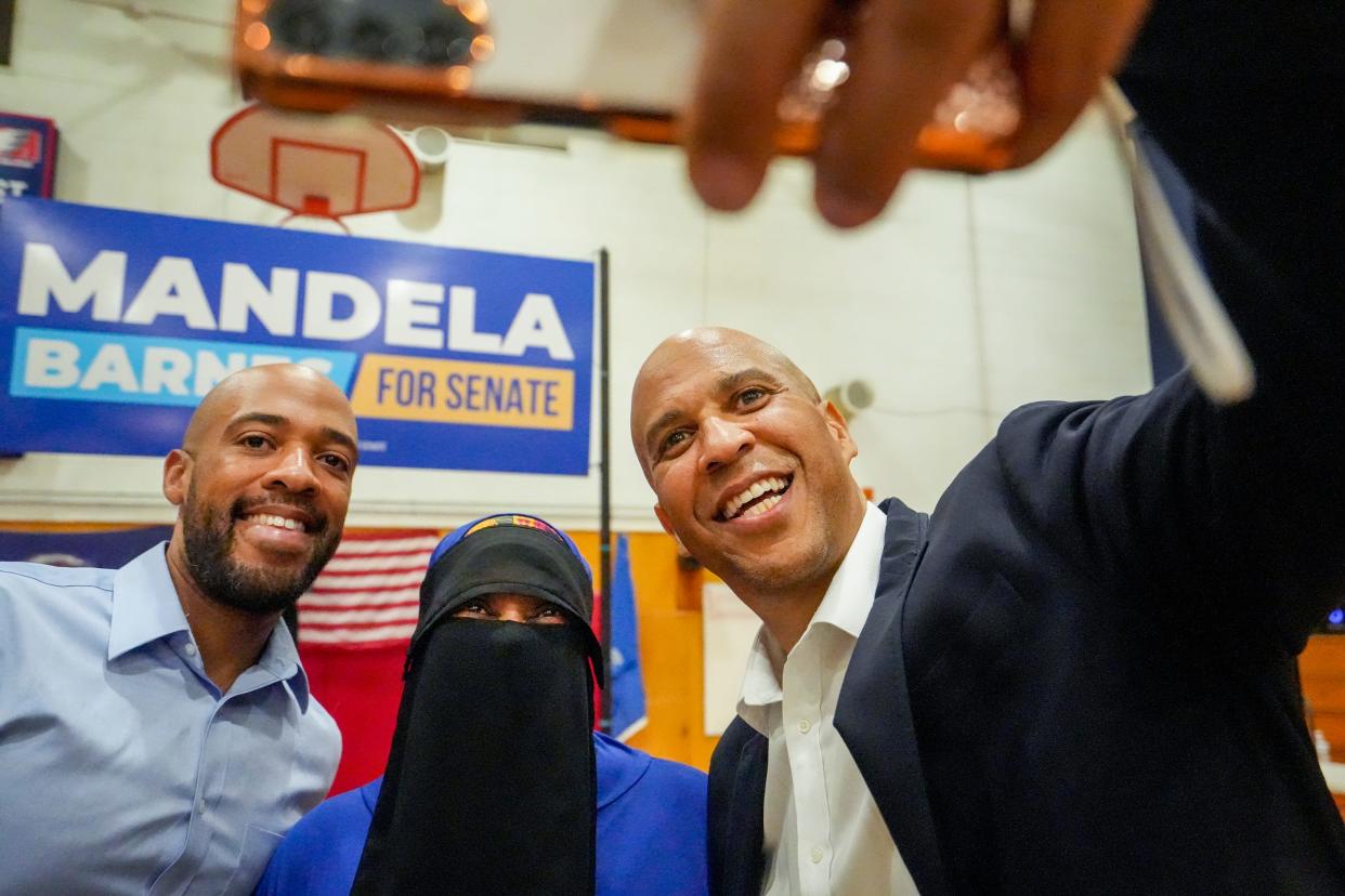 Lt. Gov. Mandela Barnes, left, and Democratic U.S. Sen. Cory Booker of New Jersey, right, take a selfie with Afriqah Imani after a campaign rally Friday at Marshall High School in Milwaukee. Booker is backing Barnes' campaign for U.S. Senate.