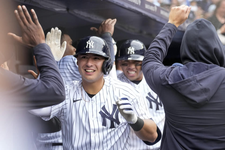 New York Yankees' Anthony Volpe, foreground, and Oswald Peraza are greeted in the dugout after scoring off of Volpe's two-run home run in the eighth inning of a baseball game against the Toronto Blue Jays, Saturday, April 22, 2023, in New York. (AP Photo/Mary Altaffer)