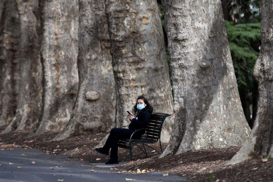 A woman takes a break on a park bench in Melbourne as the coronavirus lockdown of Australia's second-biggest city was extended by another seven days, authorities announced on June 2. 