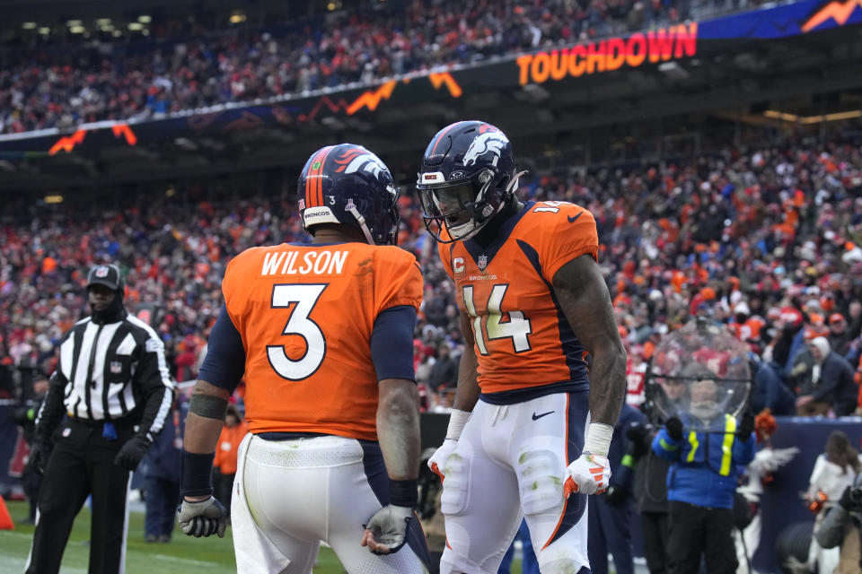 Denver Broncos wide receiver Courtland Sutton (14) is congratulated by quarterback Russell Wilson (3) after catching a touchdown pass during the second half of an NFL football game against the Kansas City Chiefs Sunday, Oct. 29, 2023, in Denver. (AP Photo/David Zalubowski)