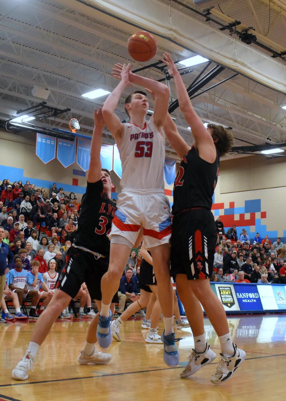 Sioux Falls Lincoln’s JT Rock puts up a shot while being defended by Brandon Valley’s Josh Olthoff and Nate Vandeberg on Saturday, March 5, in Sioux Falls.