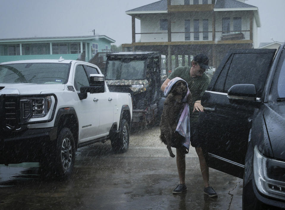 Blake Braunsube a su perra Dolly en el vehículo de su familia mientras las bandas exteriores de la tormenta Beryl comienzan a llegar a la costa el domingo 7 de julio de 2024 en Port O'Connor, Texas. (Jon Shapley/Houston Chronicle via AP)