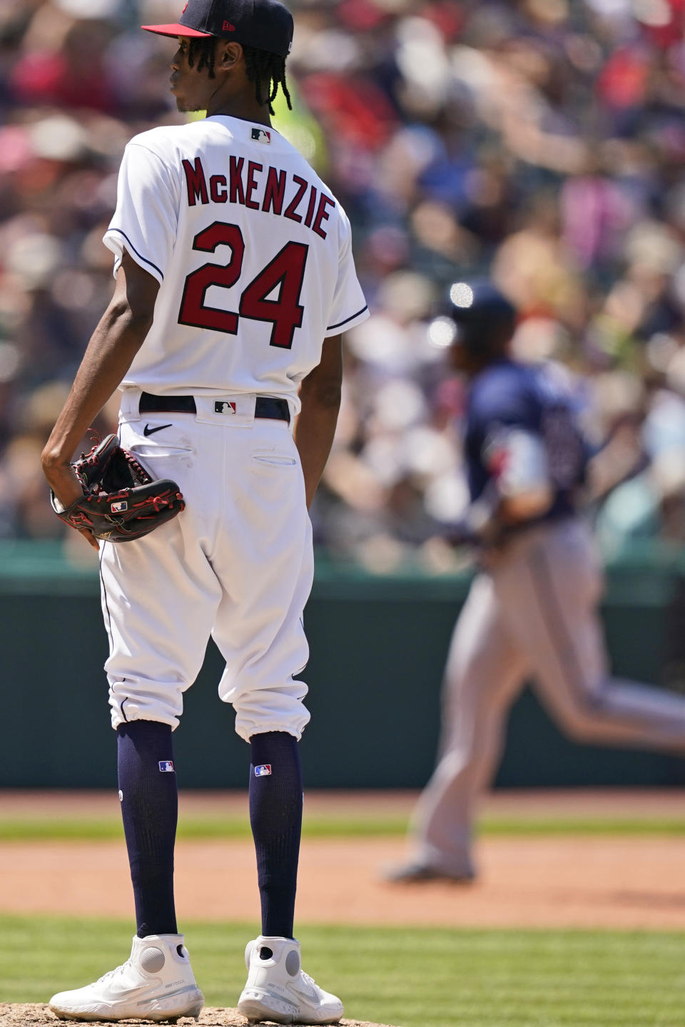 Cleveland Indians starting pitcher Triston McKenzie, left, waits for Tampa Bay Rays' Nelson Cruz to run the bases after Cruz hit a solo home run in the sixth inning of a baseball game, Sunday, July 25, 2021, in Cleveland. (AP Photo/Tony Dejak)