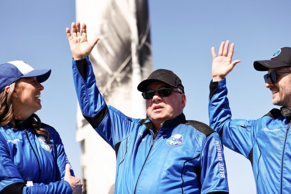 VAN HORN, TEXAS - OCTOBER 13: (L-R) Blue Origins vice president of mission and flight operations Audrey Powers, Star Trek actor William Shatner, and Planet Labs co-founder Chris Boshuizen wave during a media availability on the landing pad of Blue Origin’s New Shepard after they flew into space on October 13, 2021 near Van Horn, Texas. Shatner became the oldest person to fly into space on the ten minute flight. They flew aboard mission NS-18, the second human spaceflight for the company which is owned by Amazon founder Jeff Bezos. (Photo by Mario Tama/Getty Images) ORG XMIT: 775719639 ORIG FILE ID: 1346411238