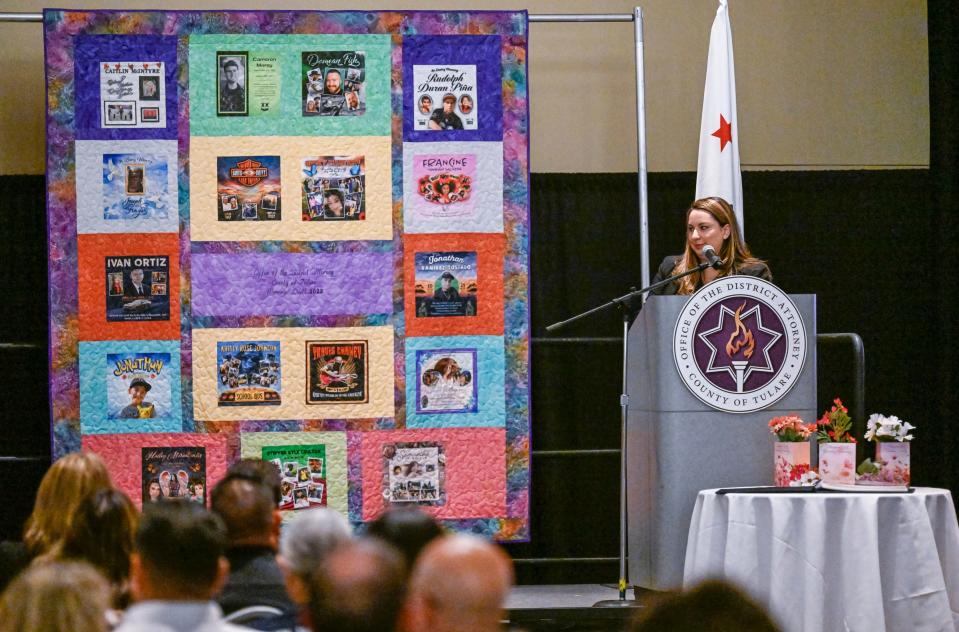 Assistant District Attorney Erica Gonzalez speaks next to the 2023 Memorial Quilt unveiled on Monday, April 24, 2023 at the Visalia Convention Center.