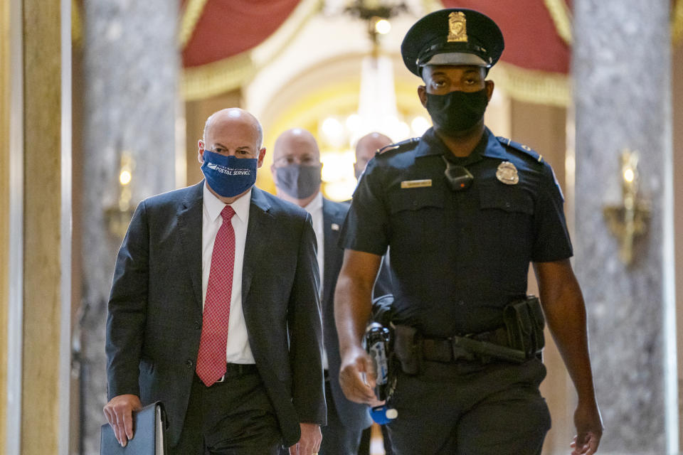 Postmaster General Louis DeJoy, left, is escorted to House Speaker Nancy Pelosi's office on Capitol Hill in Washington, Wednesday, Aug. 5, 2020. Facing public backlash, DeJoy is set to testify Friday about disruptions in mail delivery. (AP Photo/Carolyn Kaster)