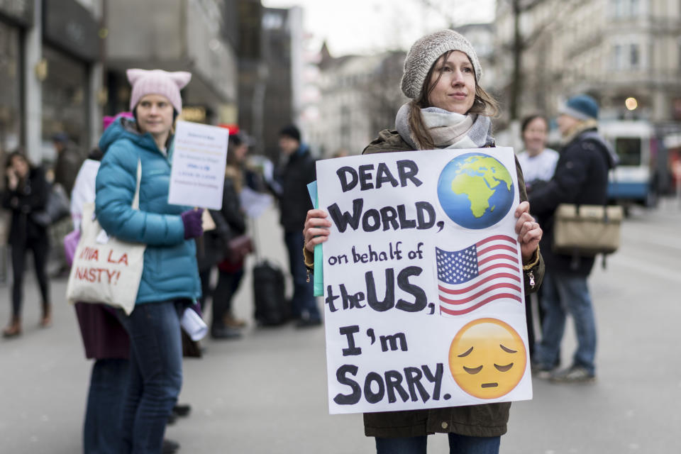 <p>A U.S. citizen holds a poster on the anniversary of the inauguration of President Trump apologizing to the world on behalf of her country, in Zurich, Switzerland, Jan. 20, 2018. (Photo: Ennio Leanza/EPA-EFE/REX/Shutterstock) </p>