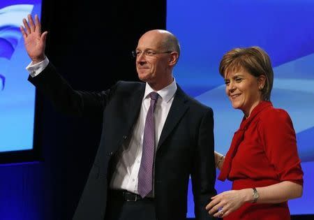 Scotland's Deputy First Minister, John Swinney, waves as he stands with First Minister, Nicola Sturgeon, after speaking at the party's spring conference in Glasgow, Scotland March 29, 2015. REUTERS/Russell Cheyne