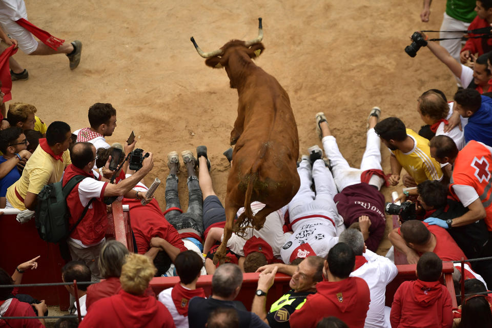 <p>A cow jumps over men laid on the ground following the running of the bulls at the San Fermin Festival, in Pamplona, northern Spain, July 14, 2017. (Photo: Alvaro Barrientos/AP) </p>