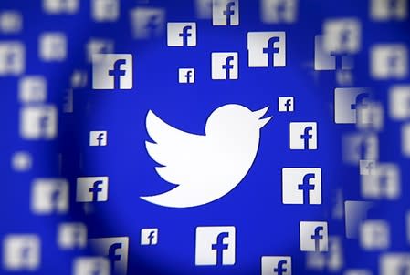 FILE PHOTO - Logo of the Twitter and Facebook are seen through magnifier on display in this illustration taken in Sarajevo