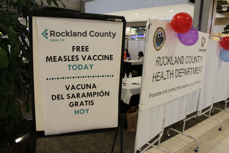A sign advertises free measles vaccinations at a pop-up clinic at the Palisades Center Mall in West Nyack