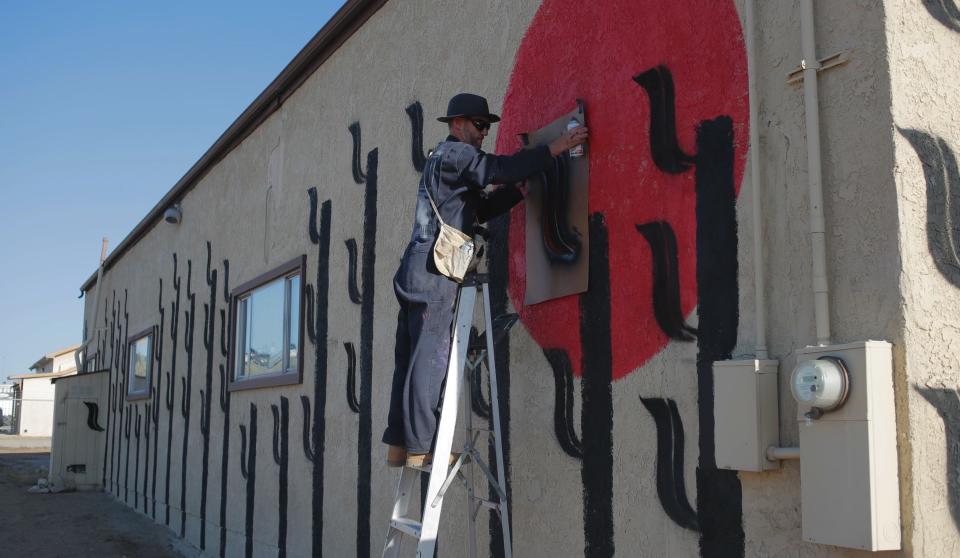 Artist Jerrold Ridenour working on the Grange Hall's newest mural, April 2024