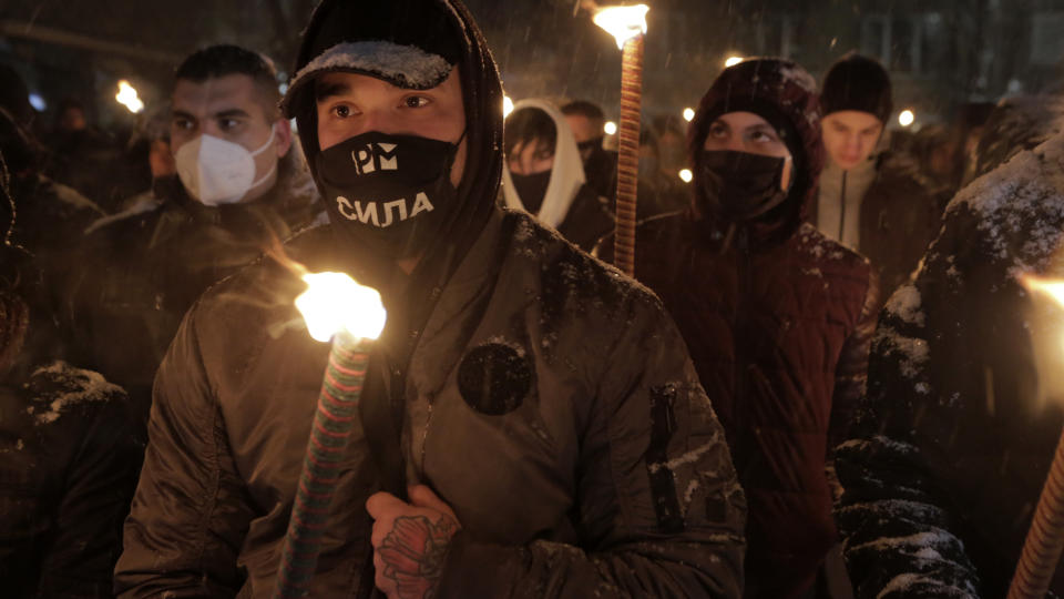 Bulgarian far-right nationalists hold torches as they gather in the country's capital, to honour a World War II general known for his anti-Semitic and pro-Nazi activities, in Sofia, Saturday, Feb. 13, 2021. Braving sub-zero temperatures, hundreds of dark-clad supporters of the Bulgarian National Union group flocked to a central square where they had planned to kick off the annual Lukov March, a torch-lit procession held every February to the former house of Gen. Hristo Lukov. (AP Photo/Valentina Petrova)