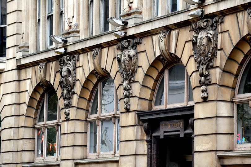 Exterior view of the building with a pale stone exterior and arched windows