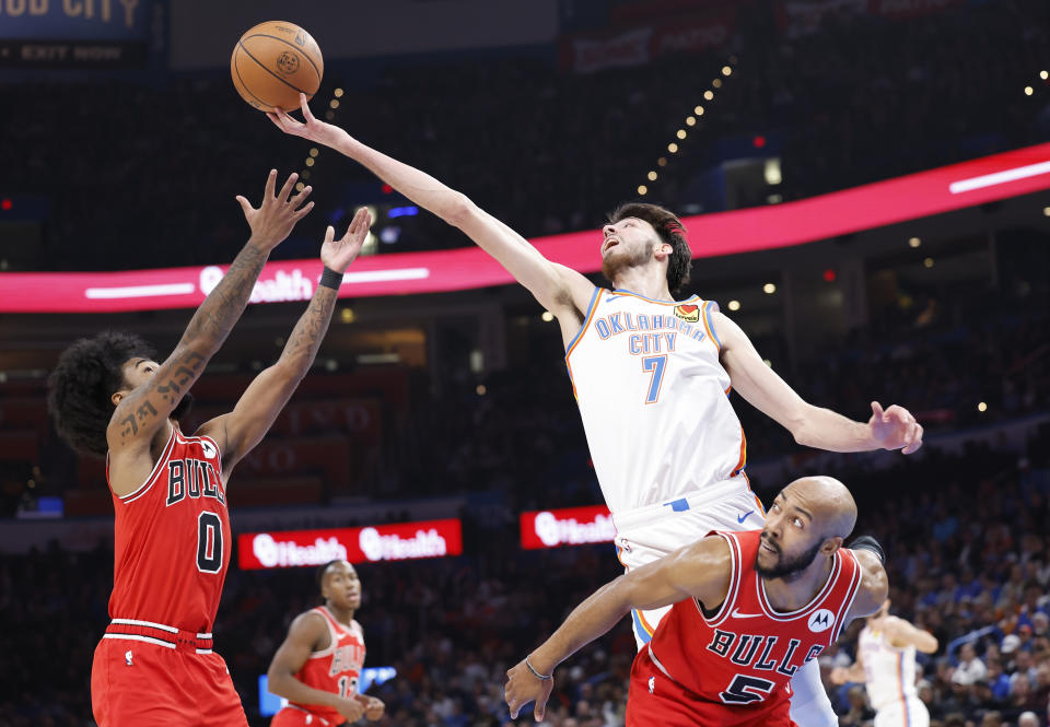 Nov 22, 2023; Oklahoma City, Oklahoma, USA; Oklahoma City Thunder forward Chet Holmgren (7) reaches for a loose ball over Chicago Bulls guard Coby White (0) and guard <a class="link " href="https://sports.yahoo.com/nba/players/6043" data-i13n="sec:content-canvas;subsec:anchor_text;elm:context_link" data-ylk="slk:Jevon Carter;sec:content-canvas;subsec:anchor_text;elm:context_link;itc:0">Jevon Carter</a> (5) during the second quarter at Paycom Center. Mandatory Credit: Alonzo Adams-USA TODAY Sports
