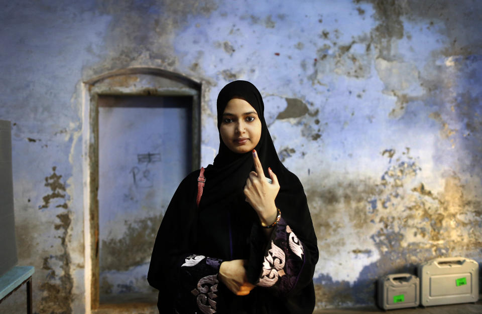 An Indian Muslim woman displays indelible ink mark on her finger after her casting at a polling station, Bengali Tola Inter college in Varanasi, India, Sunday, May 19, 2019. Indians are voting in the seventh and final phase of national elections, wrapping up a 6-week-long long, grueling campaign season with Prime Minister Narendra Modi's Hindu nationalist party seeking reelection for another five years. Counting of votes is scheduled for May 23. (AP Photo/Rajesh Kumar Singh)