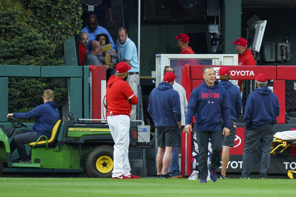 A fan, who fell into the Boston Red Sox bullpen, is brought down by the medical staff during the first inning of a baseball game against the Philadelphia Phillies, Friday, May 5, 2023, in Philadelphia. (AP Photo/Chris Szagola)
