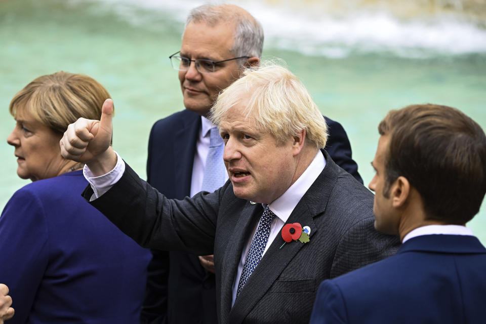 Britain's Prime Minister Boris Johnson centre gestures as he stands with Germany Chancellor Angela Merkel, left, Austalia's Prime Minister Scott Morrison background and French President Emmanuel Macron, right, during an event for the G20 summit in Rome.