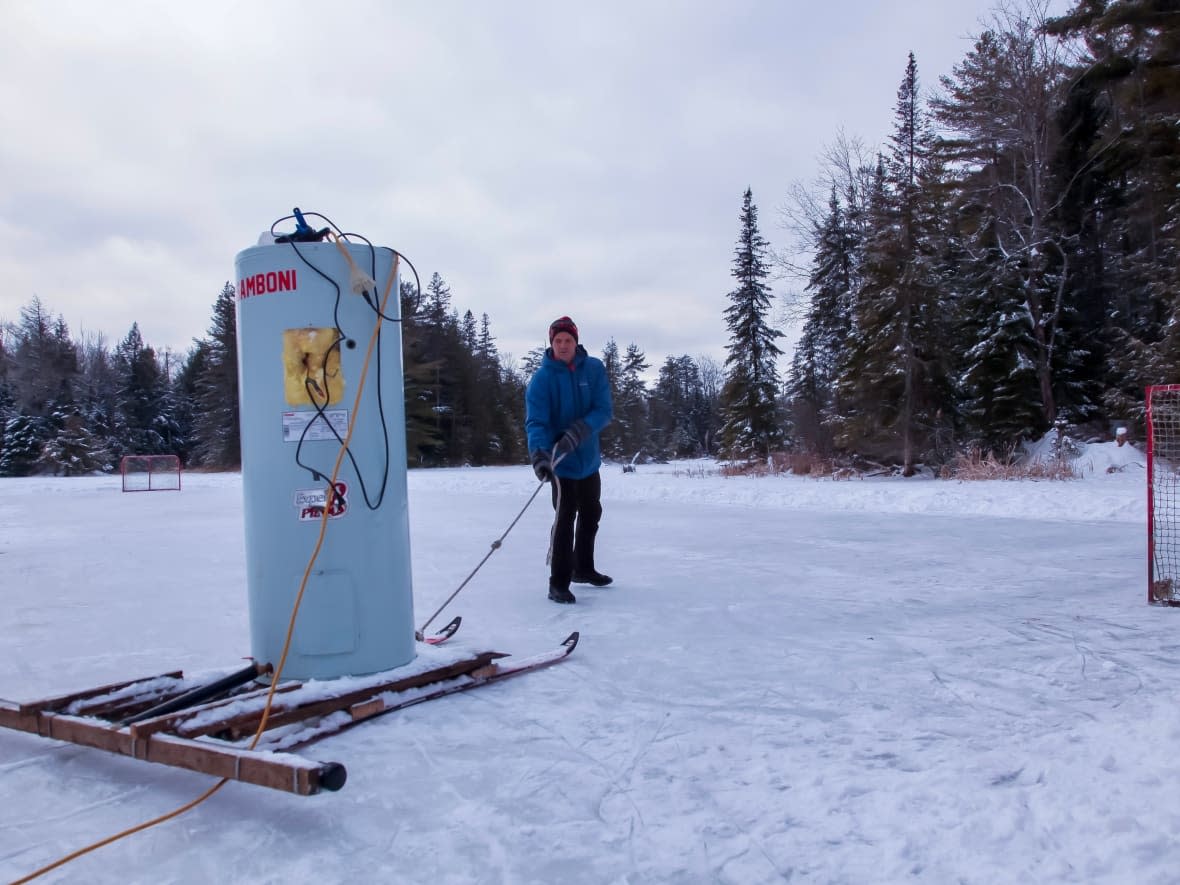 Sam Seymour used his neighbour's old hot water tank to create a homemade ice resurfacer that's perfect for smoothing out ruts and bumps on his pond hockey rink. (Stu Mills/CBC - image credit)