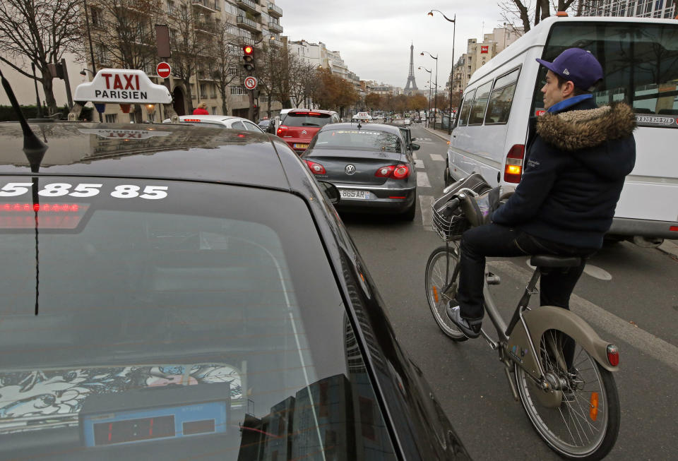 Johan Maige from Paris, rides a Velib bike-sharing program between cars in Paris, Tuesday, Oct. 30, 2012. From London’s “cycle superhighways” to popular bike-sharing programs in Paris and Barcelona, growing numbers of European cities are embracing cycling as a safe, clean, healthy, inexpensive and even trendy way to get around town. (AP Photo/Francois Mori)