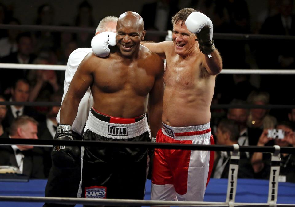 Former Massachusetts Governor and two-time presidential candidate Mitt Romney and five-time heavyweight champion Evander Holyfield celebrate after their boxing match in Salt Lake City, Utah