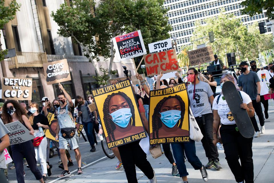 Protesters holding signs march down Spring Street during a demonstration asking for the removal of District Attorney Jackie Lacey, in Los Angeles, California, on June 17, 2020. (Valerie Macon/AFP via Getty Images)