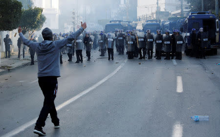 A protester confronts police, who used tear gas to disperse crowds as people marched to protest against President Abdelaziz Bouteflika's plan to seek a fifth term, in Algiers, Algeria, February 22, 2019. REUTERS/Ramzi Boudina