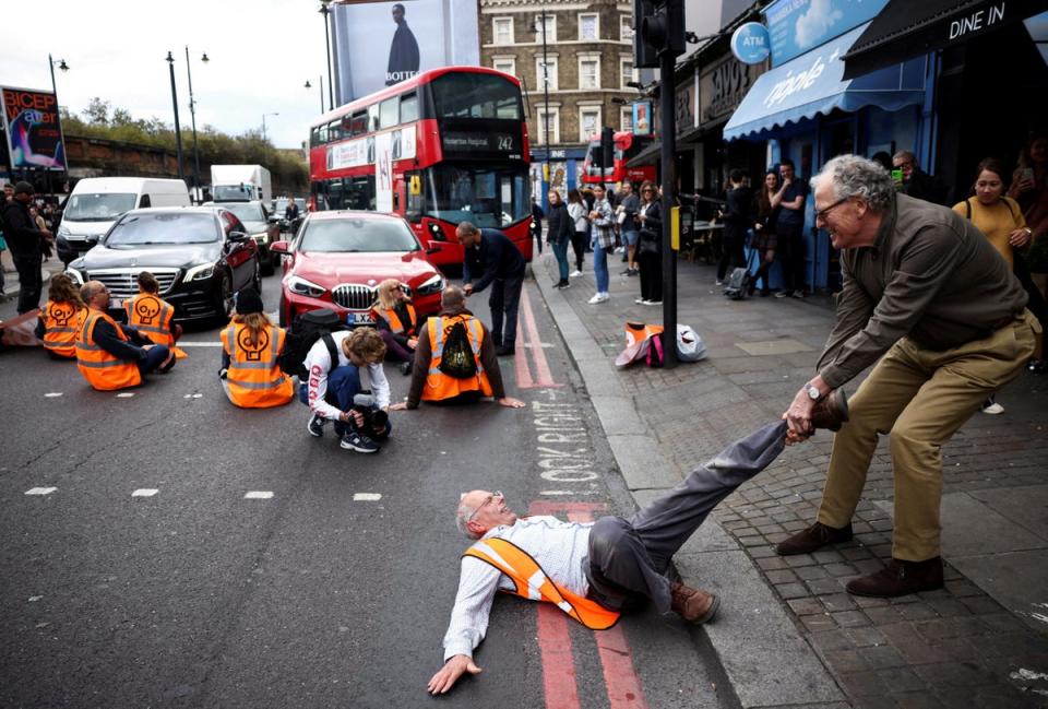 A member of the public drags an activist who is blocking the road during a Just Stop Oil protest, in London (Reuters)