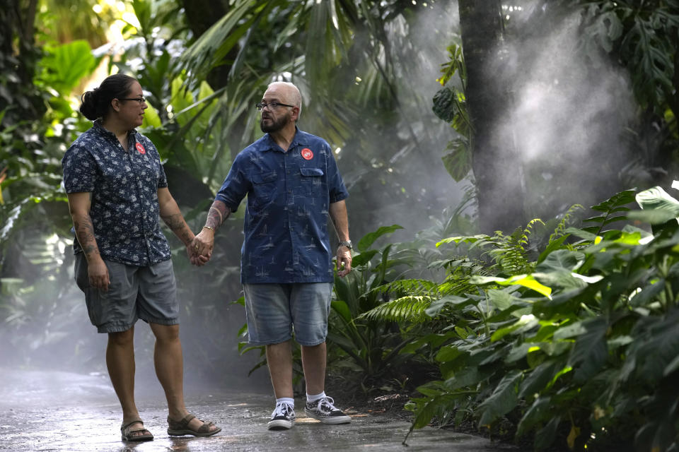 Morgan Mayfaire, a transgender man, right, walks with his wife, Ashley, Sunday, July 23, 2023, at Fairchild Tropical Garden in Miami. Mayfaire, 64, is the executive director of TransSOCIAL, a Florida support and advocacy group. (AP Photo/Lynne Sladky)