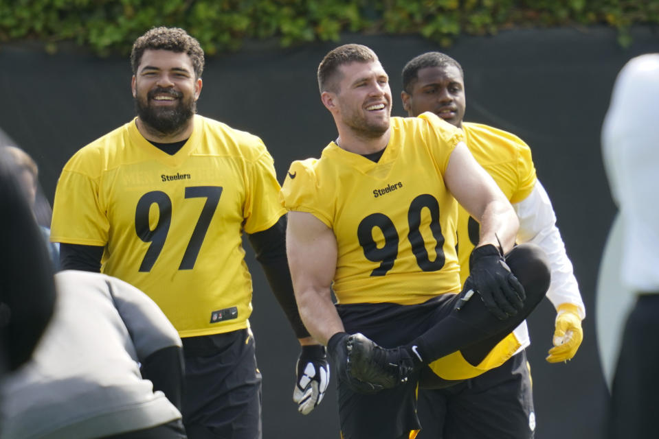 Pittsburgh Steelers' Cam Heyward, left, and T.J. Watt, center, share some laughs as they warm up during an NFL football practice, Tuesday, May 24, 2022, in Pittsburgh. (AP Photo/Keith Srakocic)