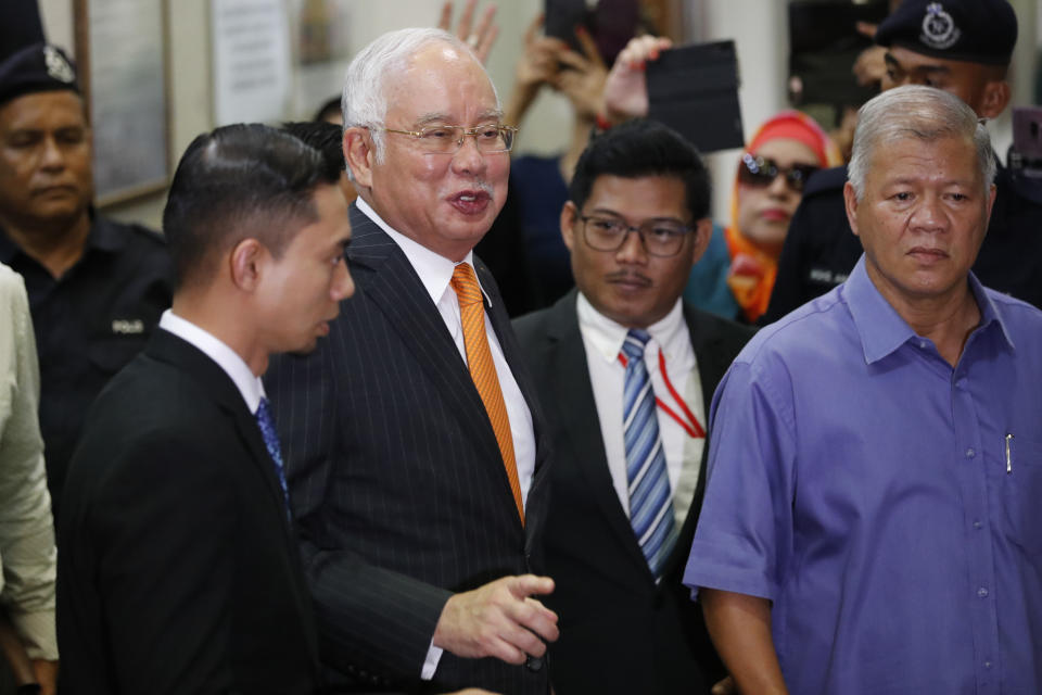 Former Malaysian Prime Minister Najib Razak, second from left, leaves Kuala Lumpur High Court in Kuala Lumpur, Monday, Nov. 11, 2019.A Malaysian judge on Monday ordered Najib to enter a defense at his first corruption trial linked to the multibillion-dollar looting at the 1MDB state investment fund that helped spur his shocking election ouster last year. (AP Photo/Vincent Thian)