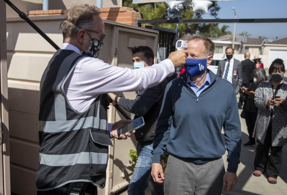 Canterbury Avenue Elementary Principal Christopher Clarke extends his arm to take LAUSD Supt. Austin Beutner's temperature.