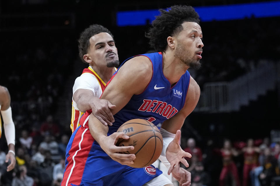 Detroit Pistons guard Cade Cunningham (2) drives past Atlanta Hawks guard Trae Young (11) during the first half of an NBA basketball game Monday, Dec. 18, 2023, in Atlanta. (AP Photo/John Bazemore)