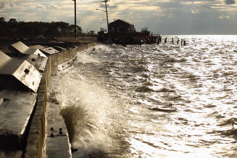 Waves pound the seawall near a crab house on Saxis Island in Virginia