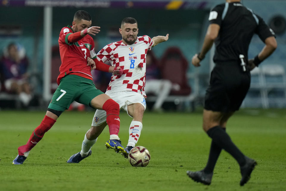 Morocco's Hakim Ziyech, left, and Croatia's Mateo Kovacic fight for the ball during the World Cup third-place playoff soccer match between Croatia and Morocco at Khalifa International Stadium in Doha, Qatar, Saturday, Dec. 17, 2022. (AP Photo/Francisco Seco)