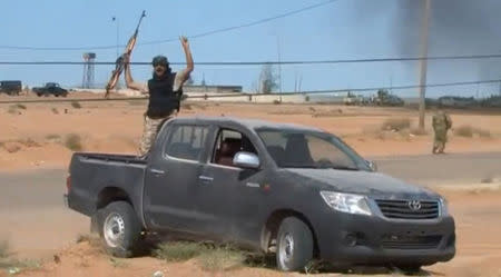 A still image from video released May 17, 2016 shows forces loyal to Libyan unity government celebrating the recapture of Abu Grain, one of the main checkpoints south of the city of Misrata, Libya from Islamic State. MISRATA TV via REUTERS.