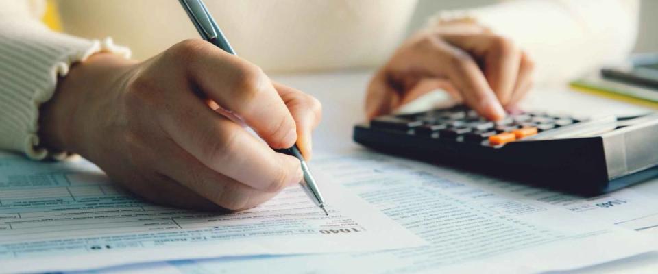 Closeup woman filling form of Individual Income Tax Return,