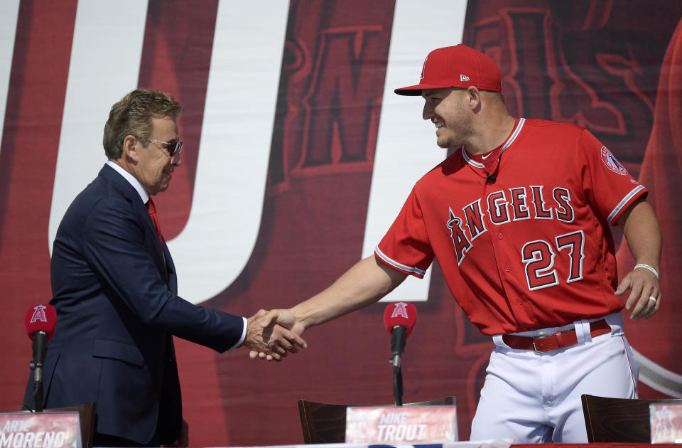 Los Angeles Angels owner Arte Moreno, left, shakes hands with center fielder Mike Trout during a news conference to talk about Trout's 12-year, $426.5 million contract, prior to the team's exhibition baseball game against the Los Angeles Dodgers Sunday, March 24, 2019, in Anaheim, Calif. (AP Photo/Mark J. Terrill)