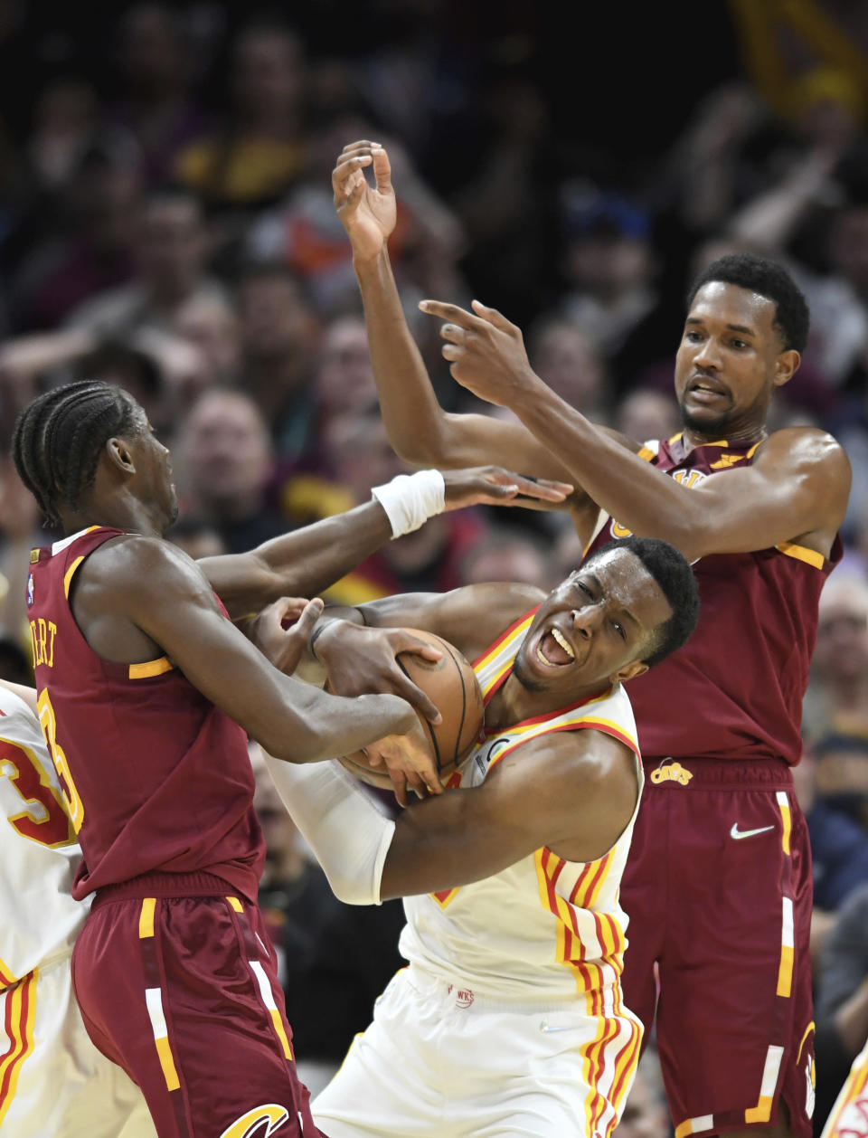 Atlanta Hawks' Onyeka Okongwu pulls in a rebound between Cleveland Cavaliers' Caris LeVert, left, and Evan Mobley during the second half of an NBA play-in basketball game Friday, April 15, 2022, in Cleveland. (AP Photo/Nick Cammett)