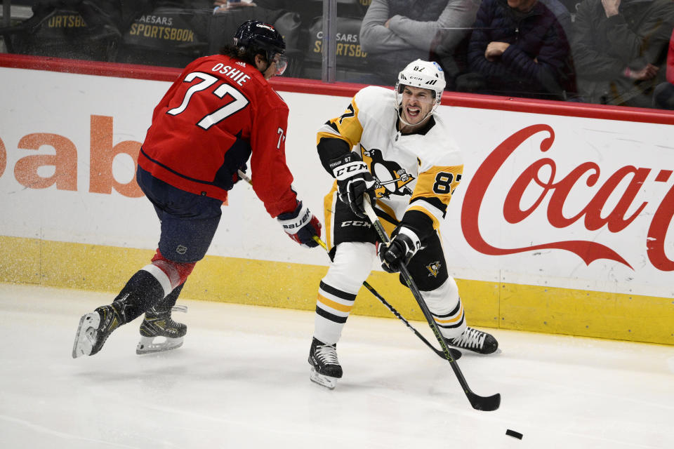 Pittsburgh Penguins center Sidney Crosby (87) passes the puck against Washington Capitals right wing T.J. Oshie (77) during the third period of an NHL hockey game, Thursday, Jan. 26, 2023, in Washington. (AP Photo/Nick Wass)