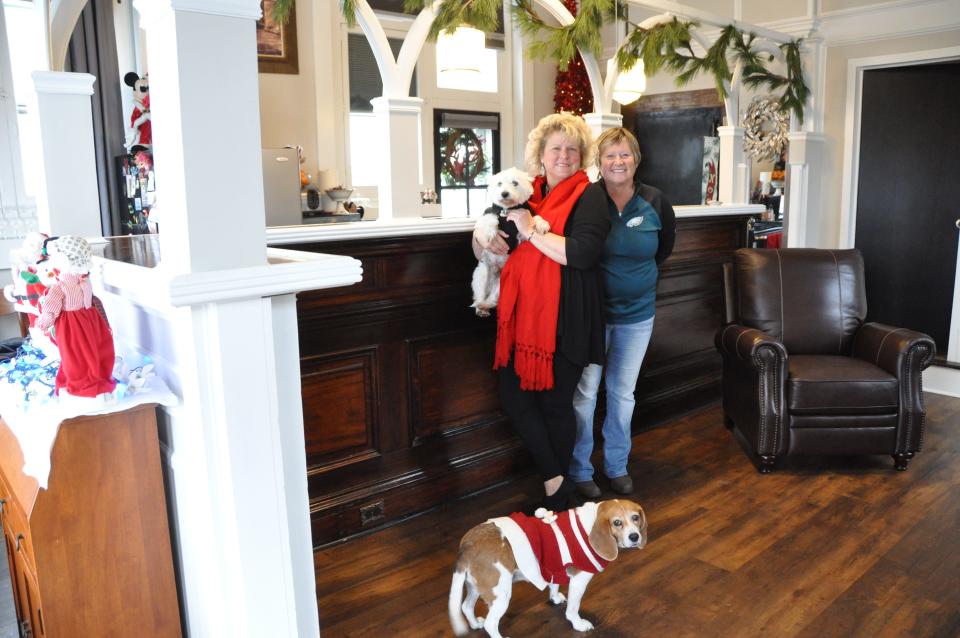 In her home on Main Street in Townsend, Maryann Coates and her sister, Beth Gabsewics, stand in the former lobby of Wilmington Trust in front of the arched teller windows that divide the living room from the kitchen. They are accompanied by Coates' dogs, Kasper (top) and Lucy Lu.