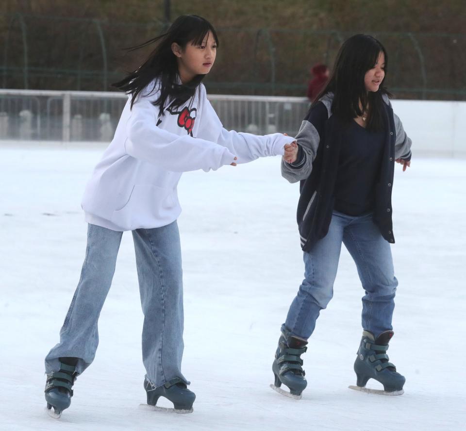 Paw Plar Soe, left, and Paw Say skate at the Lock 3 rink before The 35th Annual Welcome Santa Holiday Parade on Friday, Nov. 25, 2022 in Akron.