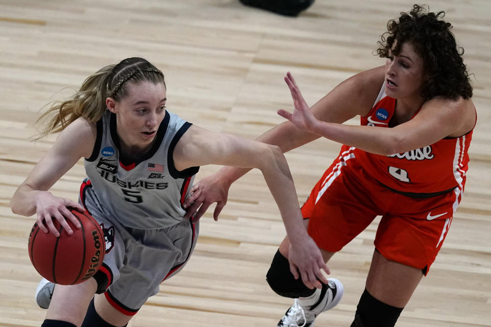 UConn guard Paige Bueckers (5) drives under pressure from Syracuse guard Tiana Mangakahia (4) during the first half of a college basketball game in the second round of the women's NCAA tournament at the Alamodome in San Antonio, Tuesday, March 23, 2021. (AP Photo/Charlie Riedel)