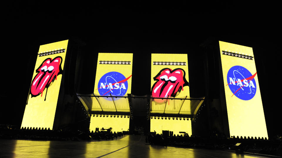 The logos for the band The Rolling Stones and NASA are displayed side-by-side on video monitors onstage before the Rolling Stones' concert at the Rose Bowl, Thursday, Aug. 22, 2019, in Pasadena, Calif. Actor Robert Downey Jr. announced from the stage before the show that NASA has officially named a rock spotted rolling across the surface of Mars by its InSight lander "Rolling Stones Rock." (Photo by Chris Pizzello/Invision/AP)