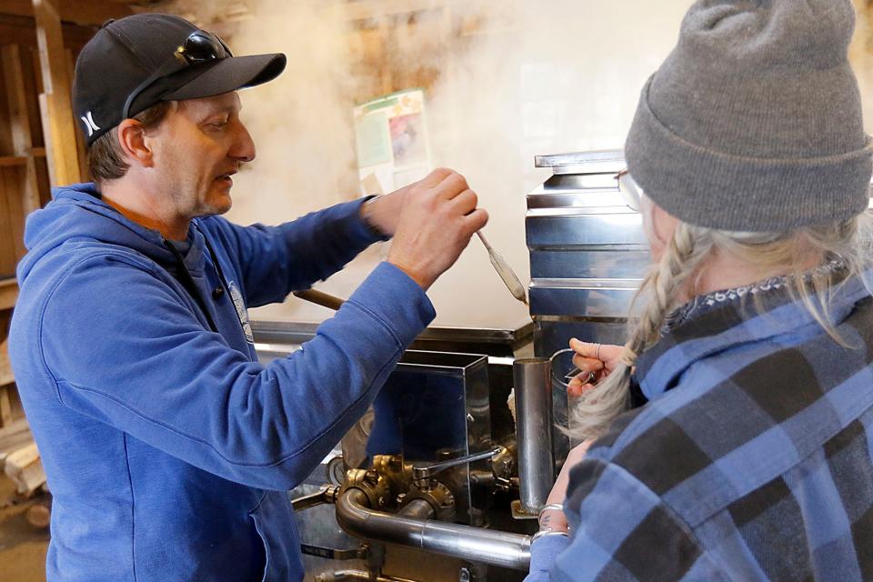 Jon Britton and Kiristin Brubach check the maple syrup as they boil it to extract the maple syrup in the Malabar Farm Sugar Shack Tuesday, Feb. 21, 2023. TOM E. PUSKAR/ASHLAND TIMES-GAZETTE