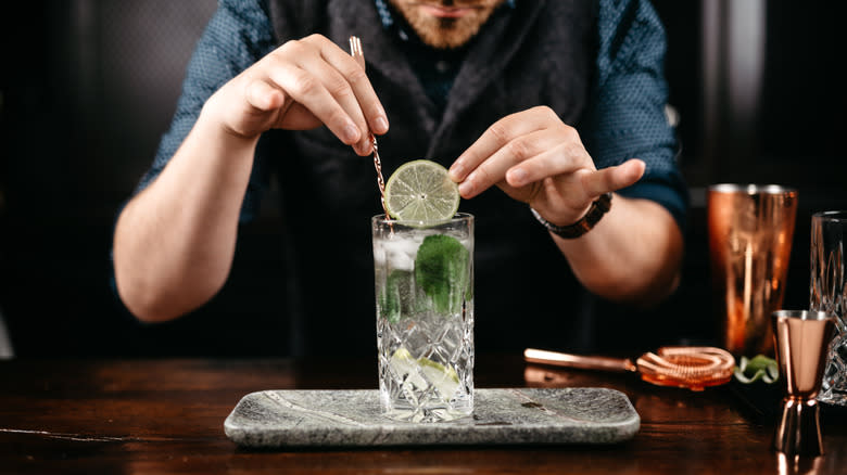 bartender preparing drink with lime