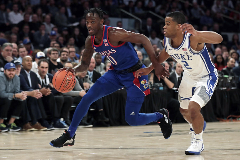 Kansas guard Marcus Garrett (0) drives to the basket past Duke guard Cassius Stanley (2) during the first half of an NCAA college basketball game Tuesday, Nov. 5, 2019, in New York. (AP Photo/Adam Hunger)