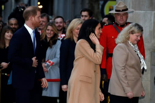 Britain's Prince Harry, Duke of Sussex (L) and Meghan, Duchess of Sussex (C) gesture on their arrival for a visit to Canada House in thanks for the warm Canadian hospitality and support they received during their recent stay in Canada, in London on January 7, 2020