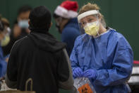 Coopers Hospital registered nurse Wendy Cassidy talks to a patient prior to a COVID-19 test at the Cooper's Poynt School in Camden, N.J. Wednesday, Dec. 9, 2020. Camden opened new testing sites because of a recent surge in COVID-19 cases. (Jose F. Moreno/The Philadelphia Inquirer via AP)