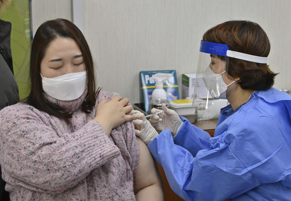 A nursing home worker, left, receives the first dose of the AstraZeneca COVID-19 vaccine at a health care center in Seoul Friday, Feb. 26, 2021. South Korea on Friday administered its first available shots of coronavirus vaccines to people at long-term care facilities, launching a mass immunization campaign that health authorities hope will restore some level of normalcy by the end of the year. (Jung Yeon-je /Pool Photo via AP)